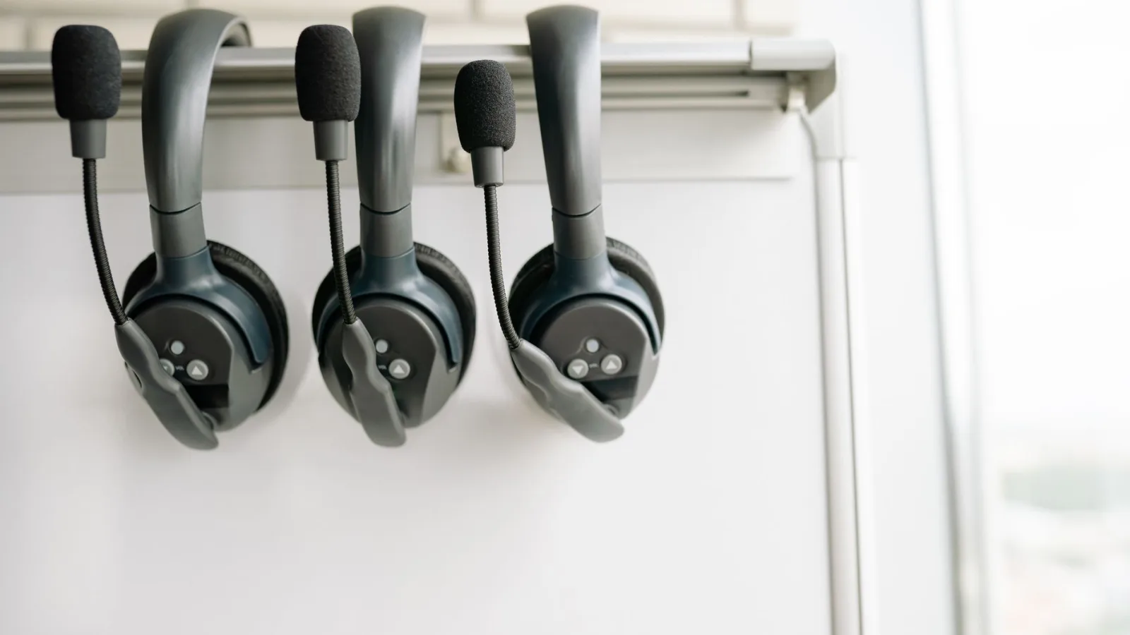 Headphones beside a waveform on a laptop screen
